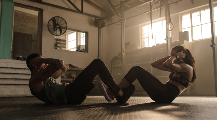 체육관에서 남녀가 운동하는 사진